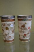 A pair of Satsuma beakers with silver rims.