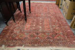 A Persian carpet, red ground with stylized decoration 255cms x 165cms.