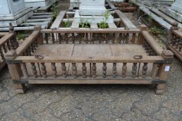 An Indian hardwood rectangular cradle or plant trough with turned spindle supports.