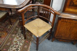 A rush seated mahogany corner armchair.