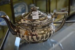 A lustre decorated teapot.