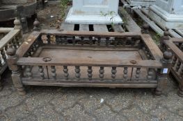 An Indian hardwood rectangular cradle or plant trough with turned spindle supports.