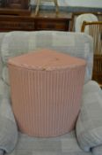 A Lloyd Loom corner linen basket.