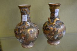 A pair of bottle shaped Satsuma vases decorated with figures.