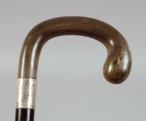 AN ANTIQUE RHINO HORN HANDLE WALKING STICK, with silver band, 90cm long.