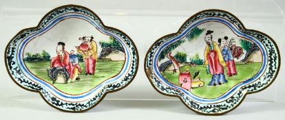 A SMALL PAIR OF CHINESE QUATREFOIL FORM ENAMEL DISHES, painted with figures in a garden, 9cm x 7.