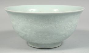 A CHINESE PALE CELADON PORCELAIN BOWL, the exterior with raised decoration depicting dragons and