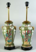 A PAIR OF CHINESE CANTON FAMILLE ROSE PORCELAIN LAMP VASES, painted with panels of figures as well