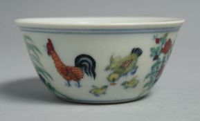 A CHINESE DOUCAI PORCELAIN CHICKEN CUP, the base six-character, 8cm diameter.