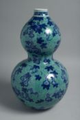 A CHINESE TURQUOISE GROUND BLUE AND WHITE DOUBLE GOURD VASE, the body decorated with gourds and