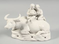 A CHINESE PORCELAIN FIGURE OF AN OXEN with two seated figures on his back, (af).