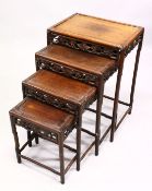 A CHINESE HARDWOOD NEST OF FOUR TABLES, each with carved frieze, tallest 71.5cm high