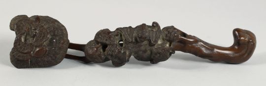 A CHINESE CARVED WOOD RUYI SCEPTRE, of naturalistic form and further carved with bats, 34cm long.