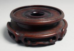 A CHINESE CARVED HARDWOOD CIRCULAR VASE STAND, to fit a base of 12.5cm diameter.