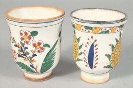 A PAIR OF TURKISH KUTAHYA POTTERY WATER CUPS, each painted with floral motifs, 8cm high.