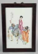 A CHINESE FAMILLE ROSE PORCELAIN PANEL IN A HARDWOOD FRAME, the panel painted with a family of