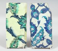 TWO 17TH CENTURY OTTOMAN IZNIK TILES, each painted with foliate motifs, 25cm x 11.5cm and 25.5cm x