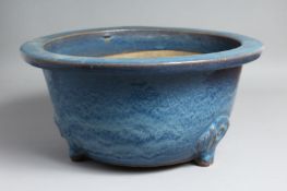 A LARGE CHINESE BLUE-GLAZED PLANTER, slightly raised on three moulded feet. 39.5cm diameter