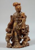 A CHINESE CARVED SOAPSTONE FIGURAL GROUP, beautifully carved to depict Guanyin holding a large