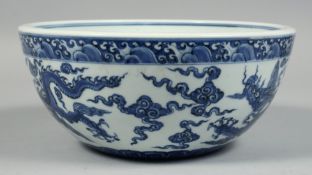 A CHINESE BLUE AND WHITE PORCELAIN BOWL, the exterior decorated with dragons and stylised clouds,