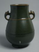 A CHINESE TEA DUST GLAZE TWIN HANDLE VASE, the base with impressed six-character mark, 23cm high.
