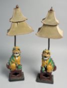 A PAIR OF CHINESE SANCAI PORCELAIN FOO DOG LAMPS, 38.5cm high overall.