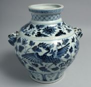 A CHINESE BLUE AND WHITE PORCELAIN TWIN HANDLE VASE, the body decorated with phoenix and flora, 27.