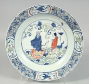 A CHINESE WUCAI PORCELAIN DISH, painted with figures and cranes, base with six-character mark,
