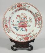 A CHINESE FAMILLE ROSE PORCELAIN PLATE with carved hardwood stand, plate 22.5cm diameter.