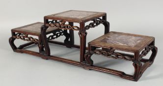 A CHINESE RED MARBLE INSET THREE TIER HARDWOOD STAND, with two stands at equal height and a raised