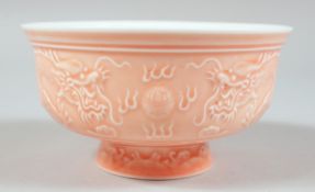 A CHINESE PINK GLAZED PORCELAIN BOWL, the exterior with raised decoration depicting dragons and