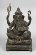 AN INDIAN BRONZE FIGURE OF GANESH, seated on a rectangular base raised on four feet, 16cm high.