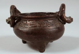 A CHINESE BRONZE TWIN HANDLE TRIPOD CENSER, the handles formed as coiling chilong, censer with a