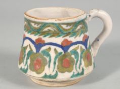 A TURKISH KUTAHYA POTTERY WINE CUP, decorated with foliate design, 7.5cm high.