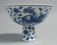 A CHINESE BLUE AND WHITE PORCELAIN STEM CUP, the exterior painted with exotic birds, flora and vine,