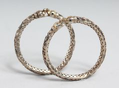 A PAIR OF INDIAN ENAMELLED SILVER OPENWORK BANGLES with Makkara heads, 7.5cm diameter.