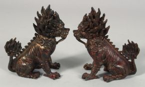 A PAIR OF CHINESE BRONZE MYTHOLOGICAL BEASTS, each with traces of gilt and red paint, 15cm high.