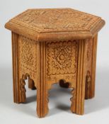 A SMALL CARVED WOODEN MODEL OF AN ISLAMIC TABLE, 9cm high.