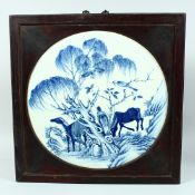 A LARGE CHINESE BLUE AND WHITE PORCELAIN PANEL, inset within a hardwood frame, the panel depicting