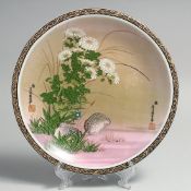A CONTEMPORARY CHINESE PORCELAIN PLATE, decorated with quail and native flora, 24cm diameter.