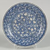 AN 18TH/19TH CENTURY OTTOMAN IZNIK GLAZED POTTERY PLATE, decorated in blue and white with