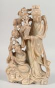 A LARGE CHINESE SOAPSTONE FIGURAL GROUP, of female figures; one holding a vase of flowers aloft, the