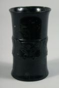 A CHINESE JADE HOLLOW CYLINDER, with a band of carved decoration, 11.5cm.