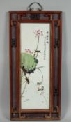 AN EARLY 20TH CENTURY CHINESE PORCELAIN PLAQUE decorated with lotus and birds, the upper-right
