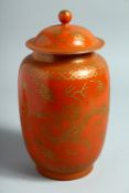 A CHINESE CORAL RED GLAZE PORCELAIN JAR AND COVER, with gilt decoration depicting dragons and the
