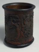 A LARGE CHINESE CARVED HARDWOOD BRUSH POT, carved with a landscape scene with buildings, mountains