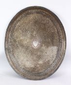 A LARGE INDIAN SILVERED METAL TRAY, with a central crest and scrolling foliate, 68.5cm x 56.5cm