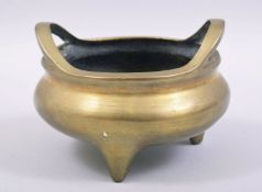 A GOOD CHINESE BRASS TWIN HANDLE TRIPOD CENSER, the base with mark, 14cm diameter.