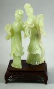 A CHINESE JADE FIGURAL GROUP ON A HARDWOOD STAND, the jade carved as two female figures, mounted