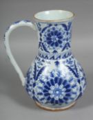 A TURKISH KUTAHYA BLUE AND WHITE GLAZED WATER JUG, painted with stylised flower heads, (AF), 22cm